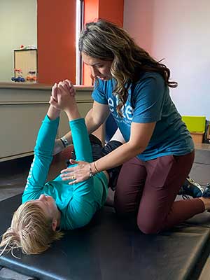 Shae, PT, treats a youth in sports therapy